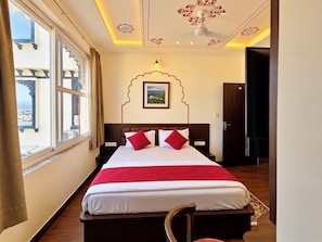 A hotel room with a large bed, a view of the city, and a decorative ceiling.
