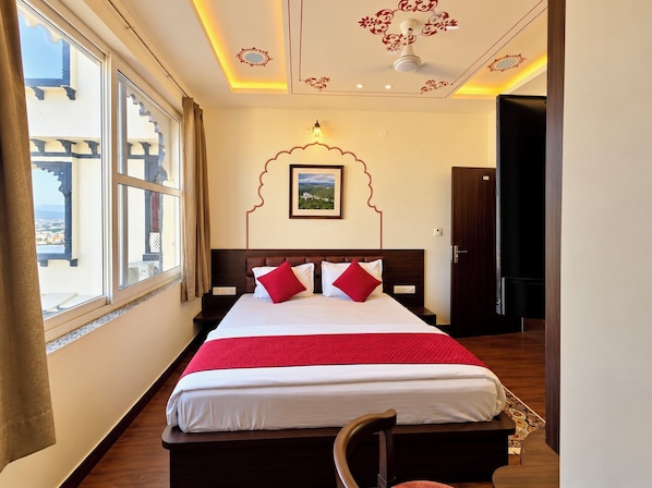 A hotel room with a large bed, a view of the city, and a decorative ceiling. - KALAKAR HAVELI - Udaipur (Udaipur)
