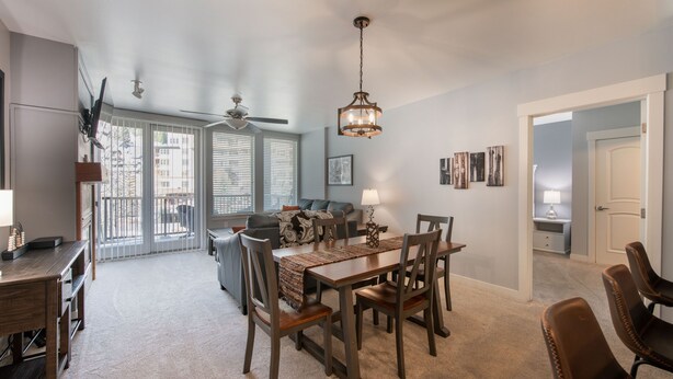 A dining area with a wooden table and chairs, a ceiling fan, and a chandelier. - Premium Unit 4285 Fraser Crossing/founders Pointe 2 Bedroom Condo (Winter Park)