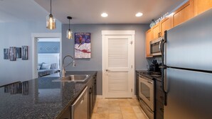 A modern kitchen with granite countertops, stainless steel appliances, and wooden cabinets. - Premium Unit 4285 Fraser Crossing/founders Pointe 2 Bedroom Condo (Winter Park)