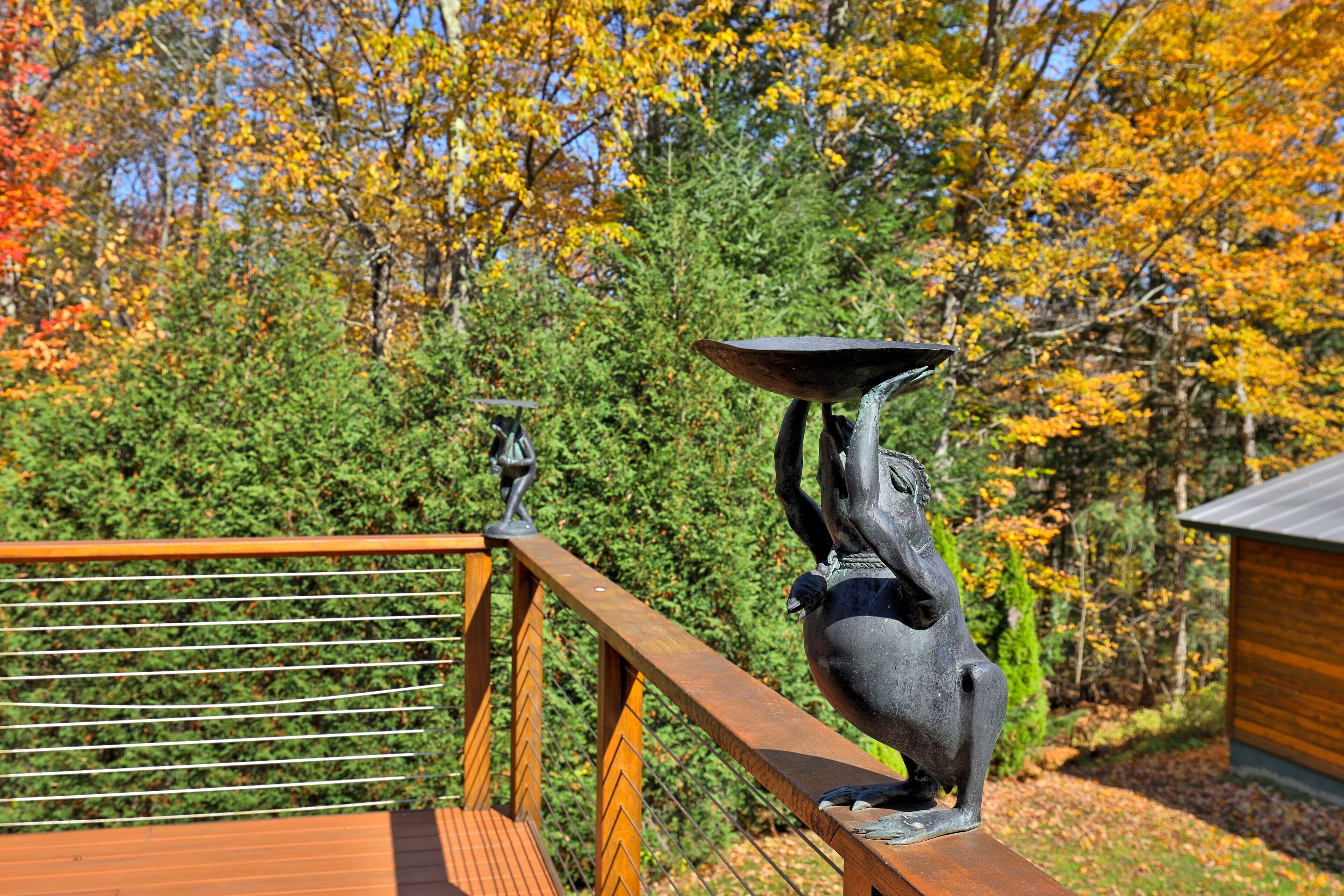 Una terraza de madera con una escultura de metal que representa a un jinete y su caballo.