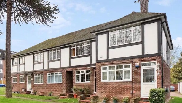 A two-story house with a brick facade, white window frames, and a front garden with a pathway. - Lovely 2 Bedrooms Flat in South Sutton (Sutton)