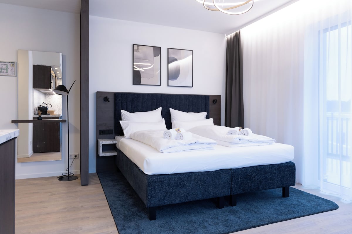 Een moderne hotelkamer met een groot bed, een bureau en uitzicht op de stad.