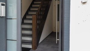 A modern staircase with a wooden handrail and a glass door leading to a room. - DLG-STAYS - "Pure 23" (Iserlohn)