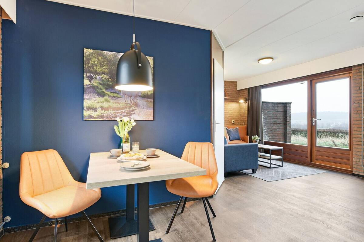 A dining area with a table, chairs, and a pendant light.