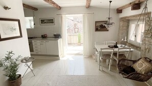A bright kitchen with white cabinets, a dining table, and a hanging chair. - Enchanting Quiet Residence Rovinj Downtown (Rovinj)