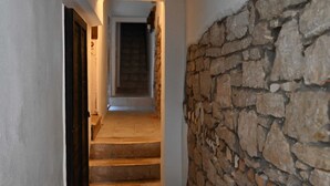 A narrow hallway with stone walls and a wooden door. - Alluring Studio Apartment Downtown Rovinj (Rovinj)