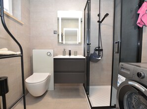 Ein kleines Badezimmer mit Toilette, Waschbecken und Dusche.