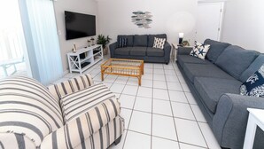 A living room with a grey sofa, striped sofa, and a coffee table.