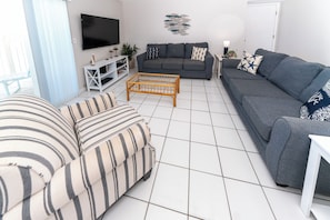 A living room with a grey sofa, striped sofa, and a coffee table.