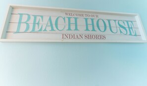 Un letrero con el texto 'BIENVENIDOS A NUESTRA CASA DE PLAYA INDIAN SHORES'.