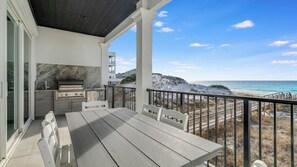 A covered outdoor patio with a grill, seating, and a view of the beach and ocean. - Azzurro Moon|Private Deeded Beach|Gulf Front Villa with Private Rooftop Pool (Seagrove Beach)