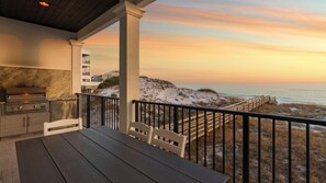 A covered outdoor area with a grill, seating, and a view of the beach at sunset. - Azzurro Moon|Private Deeded Beach|Gulf Front Villa with Private Rooftop Pool (Seagrove Beach)