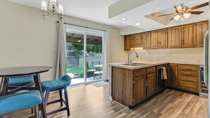 Une cuisine moderne avec des meubles en bois, un îlot central et un coin repas doté de chaises bleues.