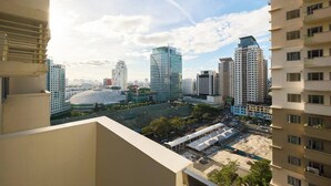 A high-rise building with a modern architectural design, featuring multiple floors and a prominent glass facade. - Skyline Stay in Araneta Cubao w/ Karaoke & Netflix  (Quezon City)