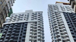 A high-rise building with multiple floors, featuring a grid-like pattern of windows and balconies. - Skyline Stay in Araneta Cubao w/ Karaoke & Netflix  (Quezon City)
