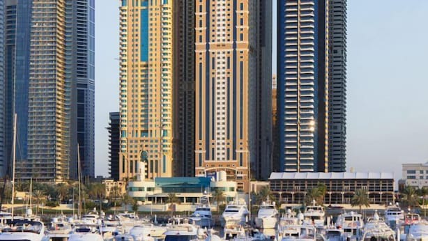 A marina with numerous boats docked, surrounded by high-rise buildings. - HAPPY SEASON I Elite Tower Dubai Marina (Dubai)