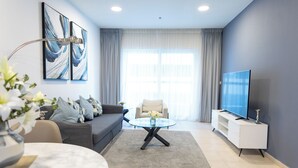 A modern living room with a sofa, coffee table, TV, and artwork on the wall. - HAPPY SEASON I Elite Tower Dubai Marina (Dubai)
