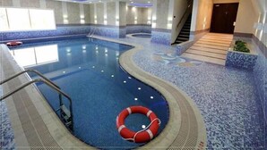 An indoor swimming pool with a lifebuoy, a staircase, and a tiled floor. - HAPPY SEASON I Elite Tower Dubai Marina (Dubai)