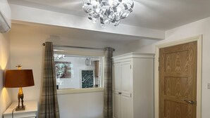 Ein Schlafzimmer mit Bett, Nachttisch, Lampe, Kleiderschrank und einer Tür.