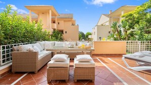 A rooftop terrace with wicker furniture, a glass table, and a bar area. - RDR446 - Gorgeous 3 bedroom Santa Maria Golf (Marbella)