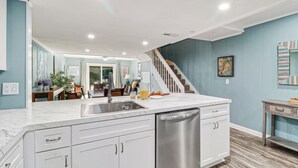 A modern kitchen with white cabinetry, a stainless steel dishwasher, and a marble countertop. - Relaxing Oceanfront Escape w/ 2 Bedrooms & Fenced-in Backyard (Hilton Head Island)