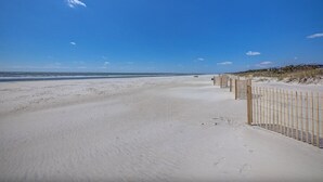 A sandy beach with a wooden fence and a clear blue sky. - Relaxing Oceanfront Escape w/ 2 Bedrooms & Fenced-in Backyard (Hilton Head Island)