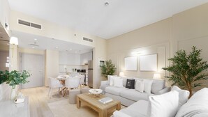 Un salon moderne avec un canapé, une table basse et un coin repas.