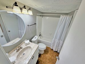Un baño con lavamanos, inodoro y ducha.