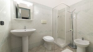 A bathroom with a pedestal sink, toilet, shower enclosure, and a bidet. - Villino Trilocale Apartments Seaside (Villaputzu)