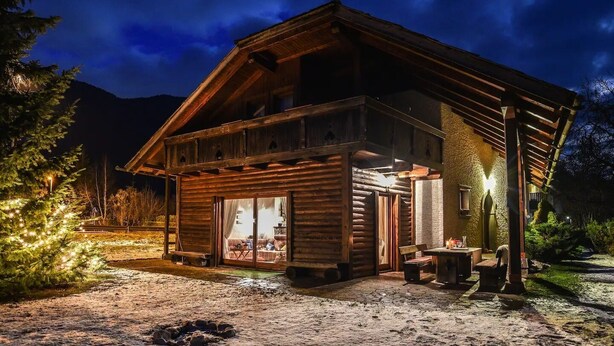 A log cabin with a large glass door, wooden exterior, and a covered porch area. - Chalet Zala, Garden, Terace, EVcharger, Sauna, Jacuzzi  (Jesenice)