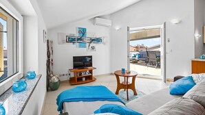 A modern bedroom with a TV, artwork, and a balcony view. - Rooftop Paradise with Sea View - Katja (Medulin)