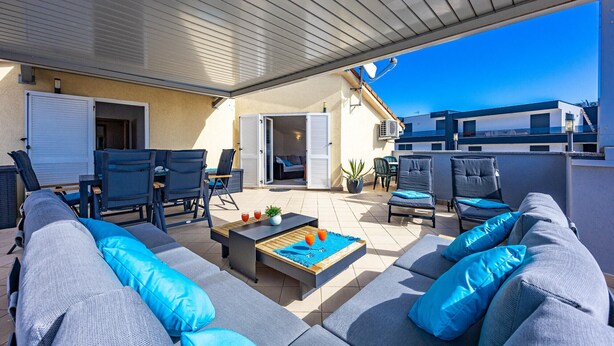 An outdoor patio with a covered seating area, including a sofa and chairs, and a small table with drinks. - Rooftop Paradise with Sea View - Katja (Medulin)