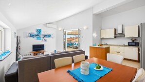 A compact living space with a dining area, kitchenette, and a sofa set. - Rooftop Paradise with Sea View - Katja (Medulin)