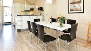 A modern kitchen with white cabinets, a microwave, and hanging pendant lights. - Splendid Holiday Home With View (Grossenbrode)