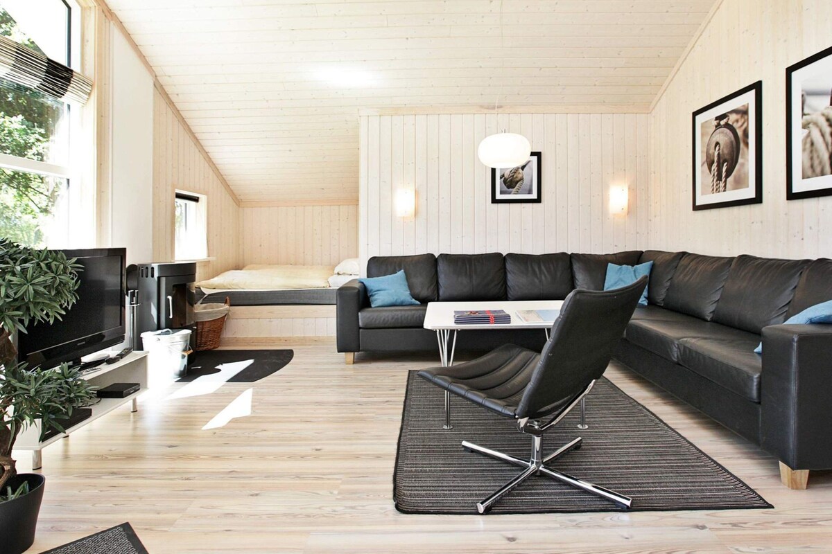 Ein modernes Wohnzimmer mit Sofa, Couchtisch, Fernseher und Essbereich.