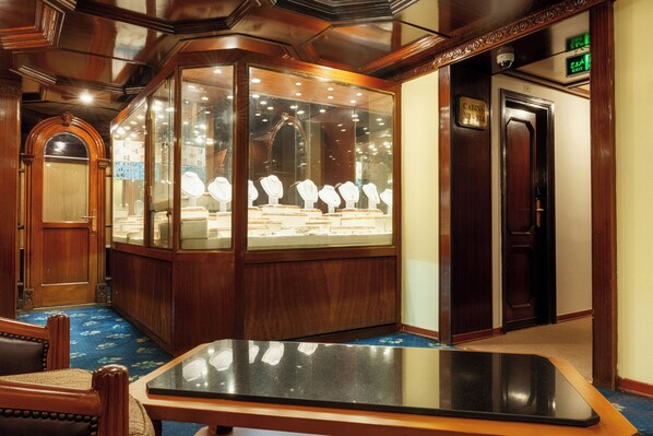 A room with a display case of jewelry, a wooden door, and a blue carpet. - Orient Nile Romance Nile Cruise - Every Saturday from Luxor for 07 & 04 Nights - Every Wednesday From Aswan for 03 Nights (Luxor)