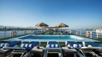 Una piscina al aire libre, tumbonas