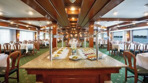 A dining area with a long table, chairs, and a buffet setup. - Orient Nile Romance Nile Cruise - Every Saturday from Luxor for 07 & 04 Nights - Every Wednesday From Aswan for 03 Nights (Luxor)
