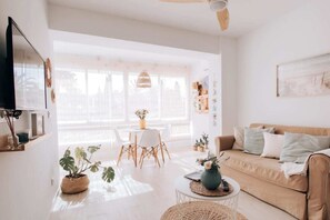 A bright living room with a sofa, coffee table, and dining area. - El Nido by BH Marbella (Marbella)