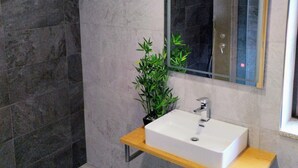 A modern bathroom with a rectangular sink, a mirror, and a potted plant. - R3 Service Casa do Pomar (Vouzela)