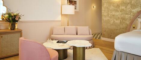 Una habitación de hotel moderna con sofá, una mesita de centro, una lámpara y una cama.
