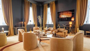 A spacious living room with leather sofas, a coffee table, and a bookshelf. - Les Bains De Spa (Spa)
