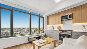 A modern kitchen with a large window, a microwave, and a stove.