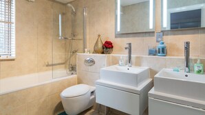 Ein modernes Badezimmer mit Badewanne, Toilette und einem Waschbecken-Doppelplatz.