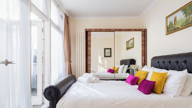 Ein Hotelzimmer mit einem großen Bett, einem Spiegel und Blick ins Freie.