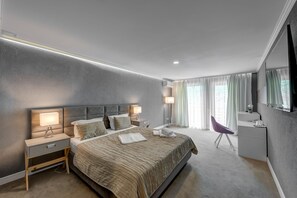 A modern hotel room with a large bed, bedside lamps, a desk, and a chair. - Hotel Roberto Slanic Prahova (Slanic)
