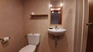 Ein Badezimmer mit Toilette, Waschbecken und Spiegel.