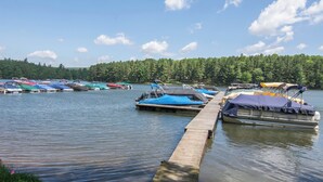 Un lago tranquilo con varias embarcaciones amarradas a un muelle de madera.