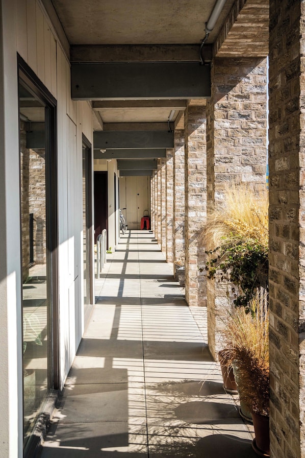 Corridors lead to a door at the end, lined with columns and a brick wall.